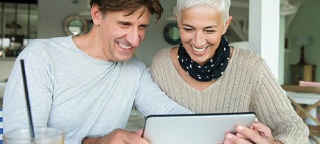 man and woman smiling at iPad