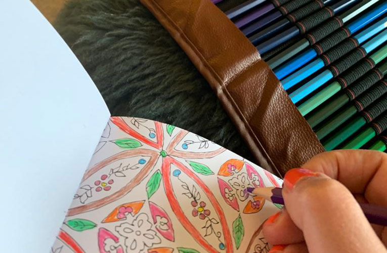 Person fills in a colouring book