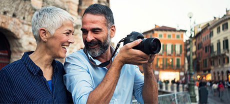 man holding a camera while the man and woman are smiling at each other