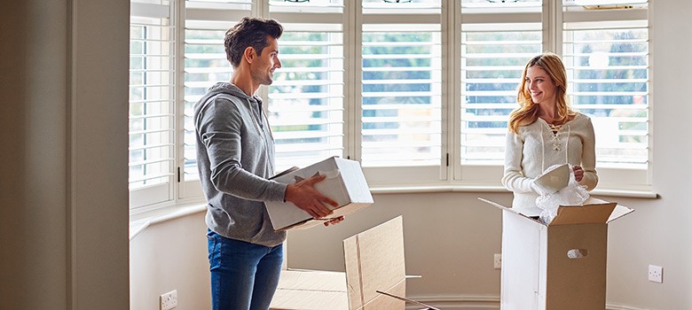 Two home buyers unpack boxes in their new house