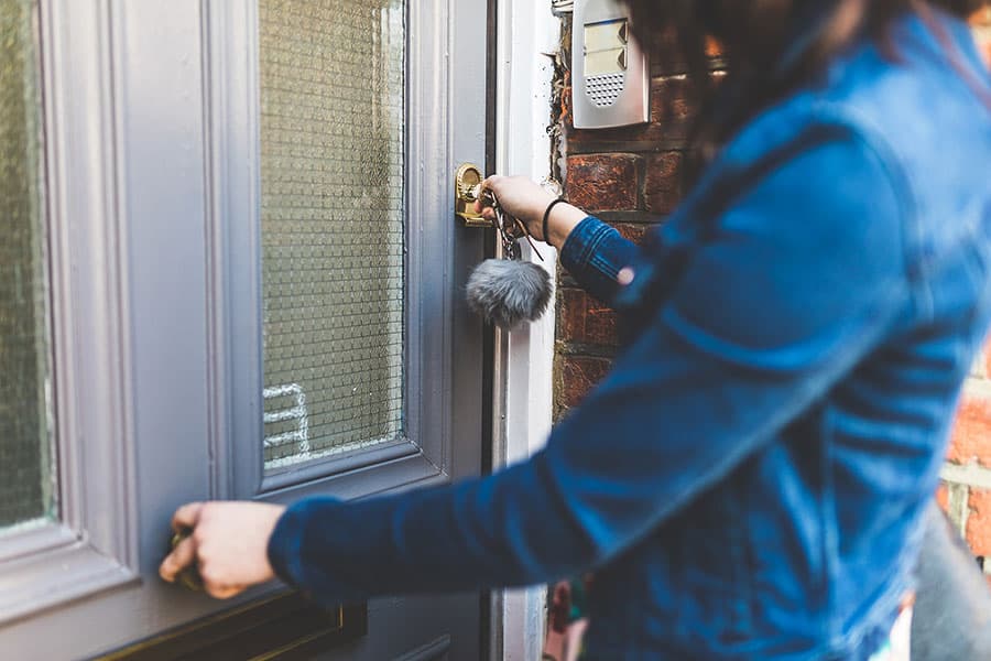 Woman opening front door with keys
