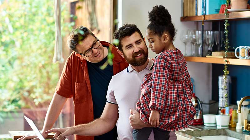 Two adults and a child together in a kitchen setting