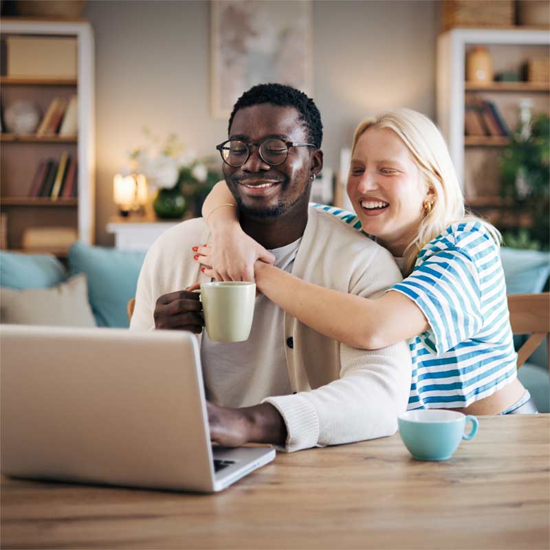 happy couple looking at laptop together