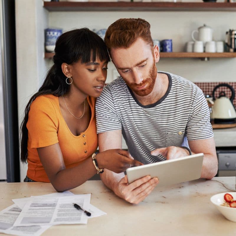 woman and man looking and pointing at a tablet device
