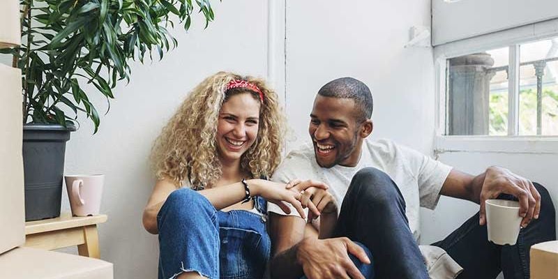 Couple sitting on floor smiling.