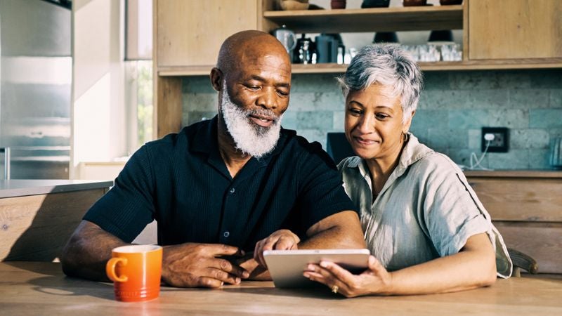 A man and woman looking at a tablet