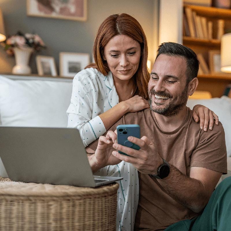 Couple sitting together looking at a phone