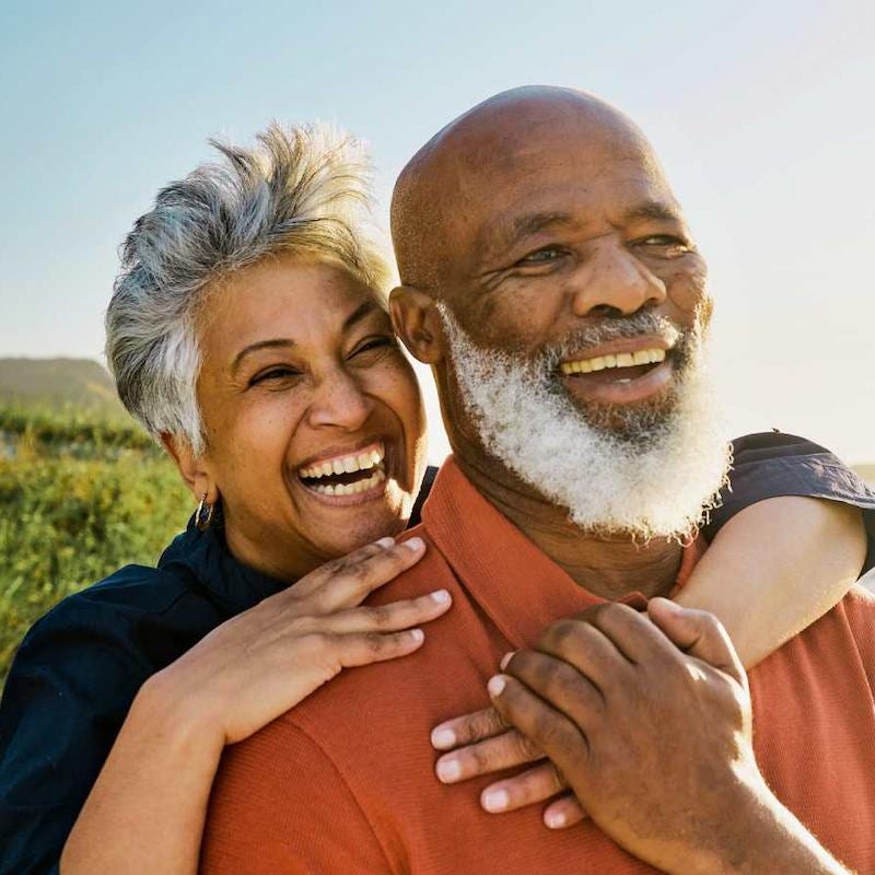 older couple together smiling, outside