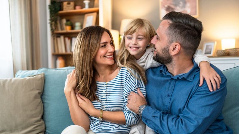 Smiling family sat on couch