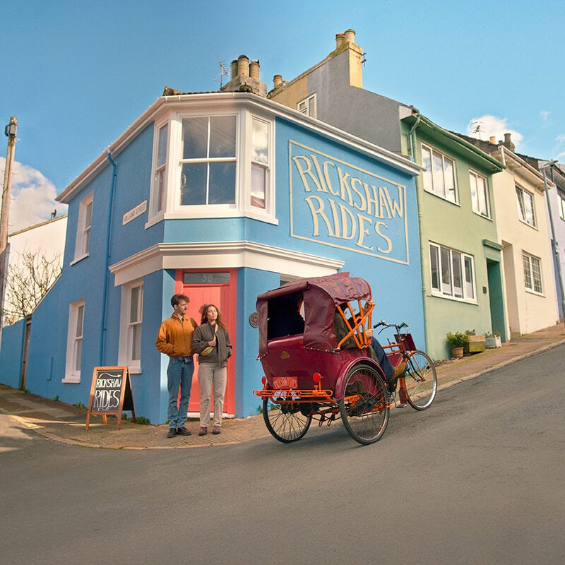 Young couple standing by a rickshaw that is offering rides