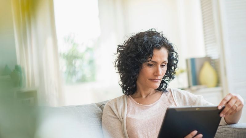Woman on couch using tablet